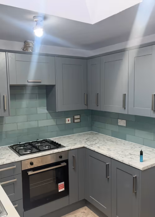 Grey kitchen with teal tiles