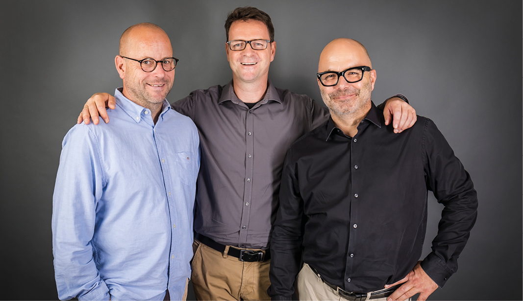 Drei Männer als Küchenexperten posieren vor grauem Hintergrund – Team von Küche Aktiv mit Erfahrung in moderner Küchenplanung, Beratung und individuellem Küchendesign.