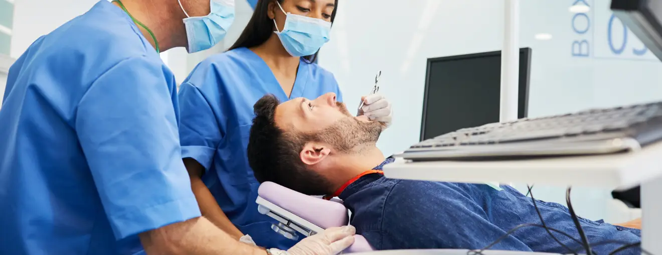 A man is getting his teeth cleaned by a dentist.
