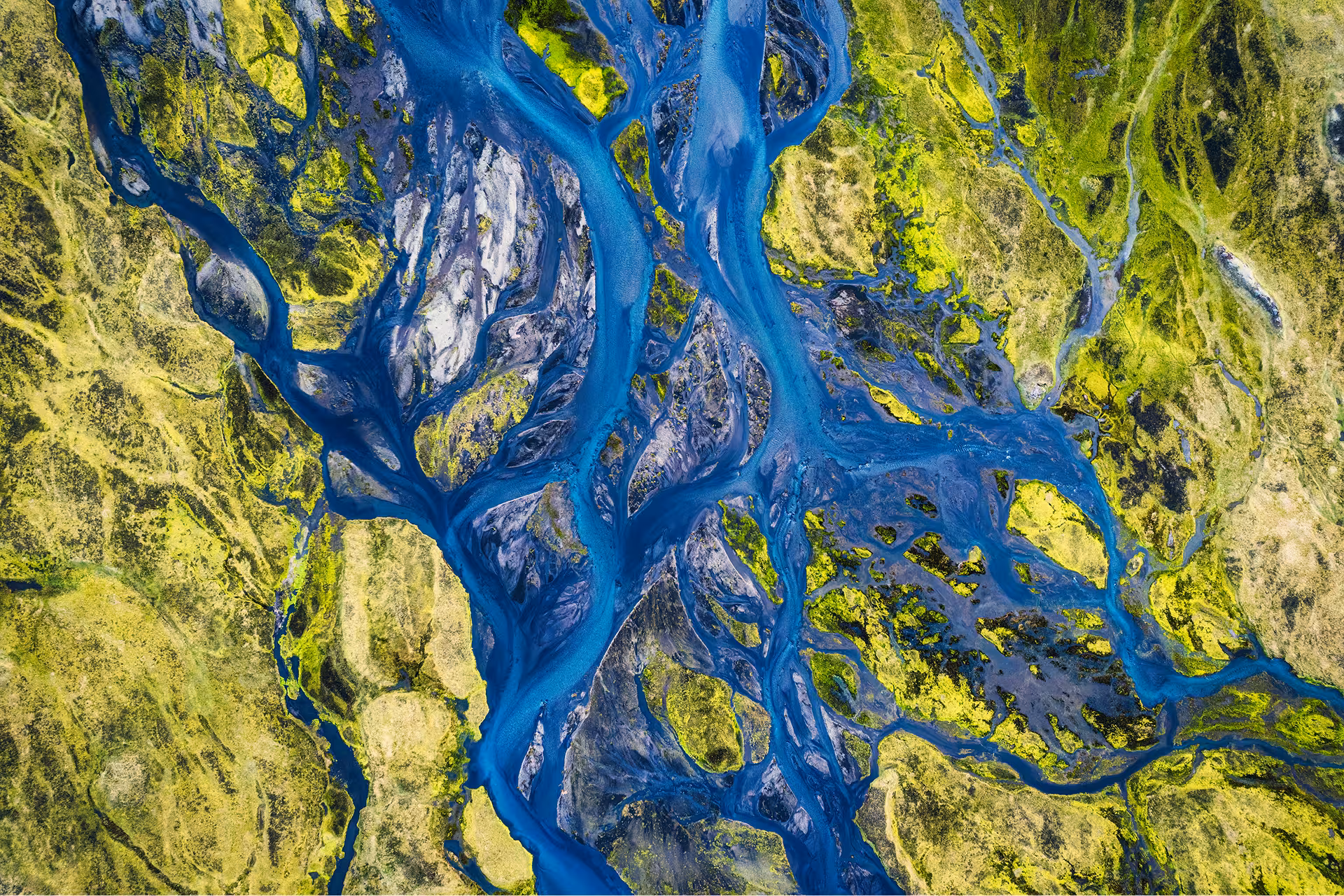 Satellite view of a sprawling river delta, meandering through green land on either side.