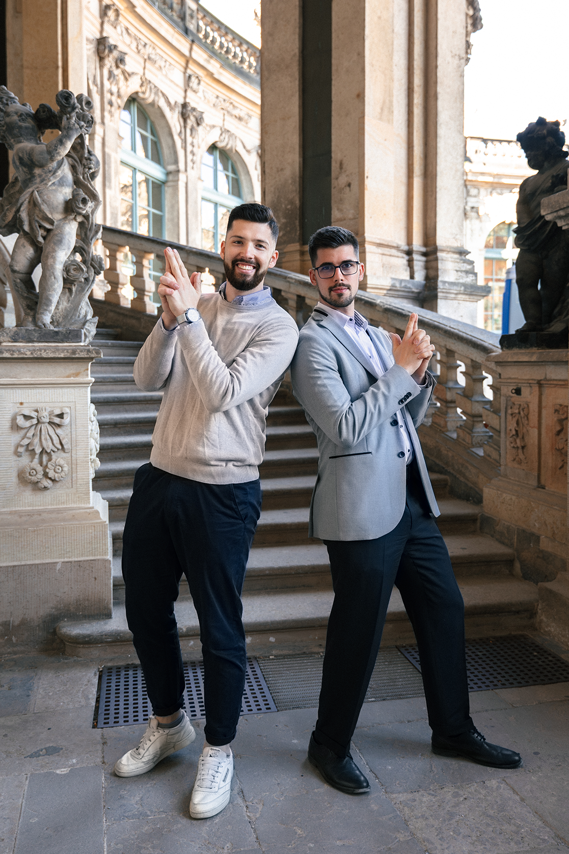 Kilian Kopsch und Lukas Janik stehen Rücken an Rücken im Dresdner Zwinger und posieren lächelnd in Anspielung auf eine Agentenszene.