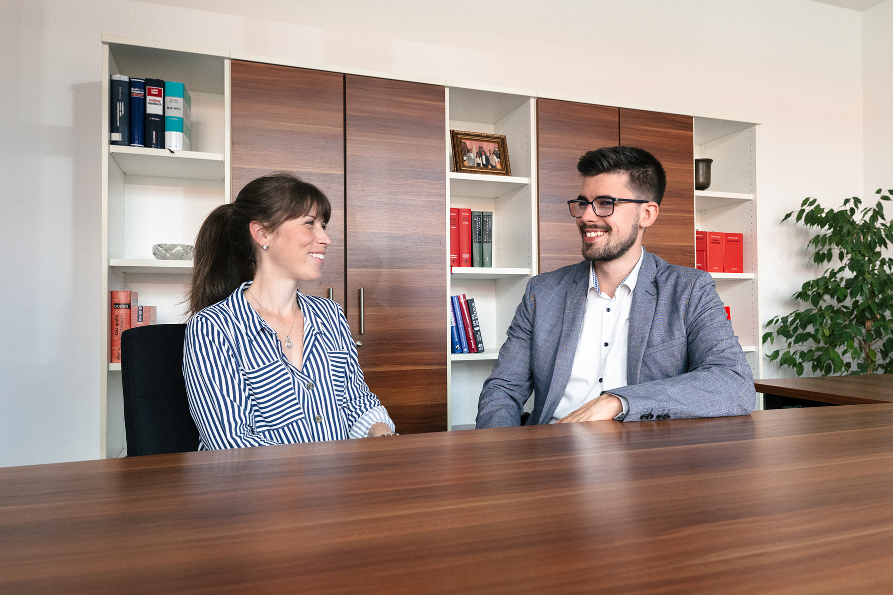 Julia Müller und Kilian Kopsch von Provenia sitzen sich im Büro gegenüber und unterhalten sich freundlich.