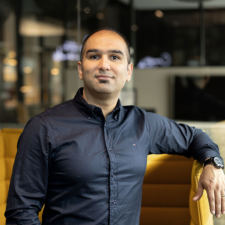 Mann in dunkelblauem Hemd sitzt in einer modernen Lounge.