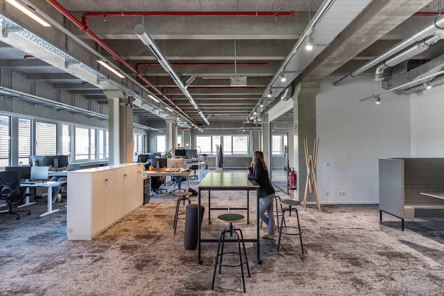 Offenes Großraumbüro mit modernen Arbeitsplätzen und industriellem Stil.