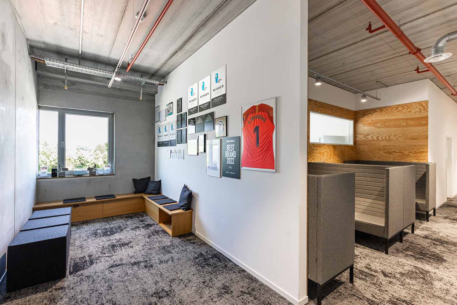 Gemütlicher Loungebereich mit Sofas, Teppich und modernen Wanddetails.

