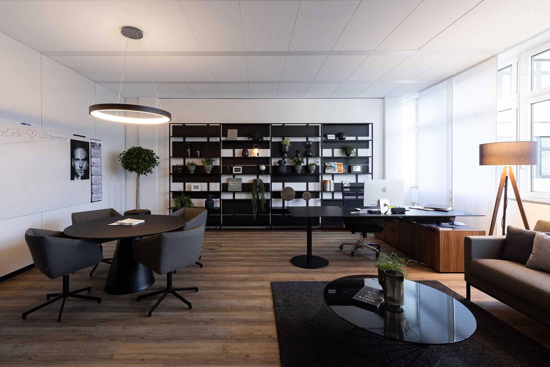 Elegantes Chefbüro mit Bücherregal, Lederelementen und warmem Lichtkonzept.

