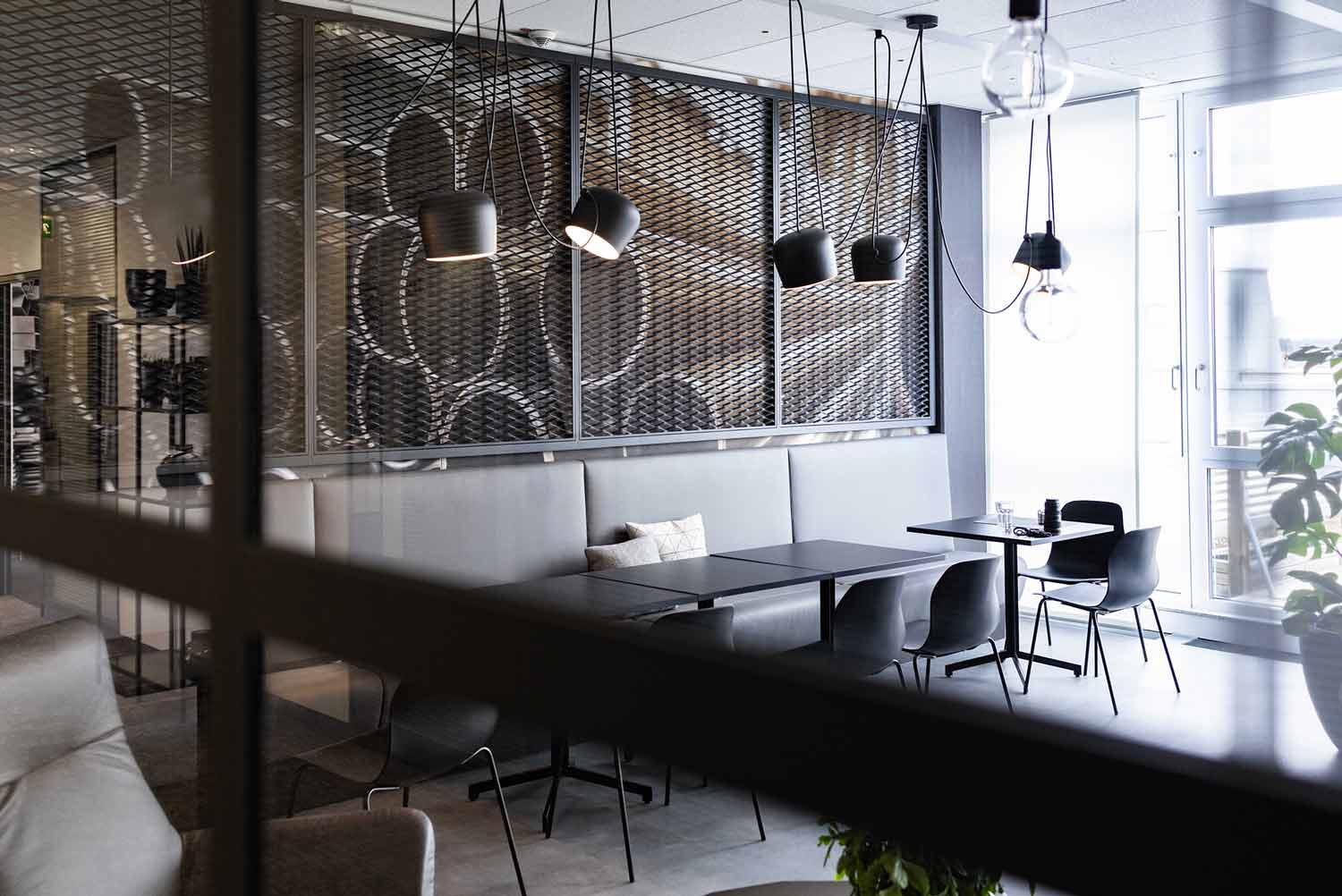 Helles Restaurant- oder Büro-Café mit modernen Leuchten und grafischem Wanddesign.