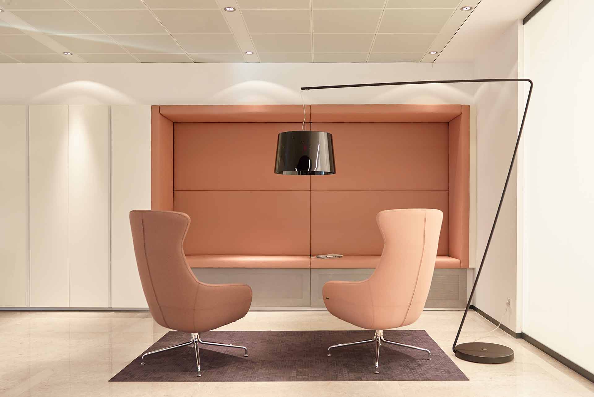 Minimalistischer Besprechungsraum mit runden Sesseln und heller Beleuchtung.