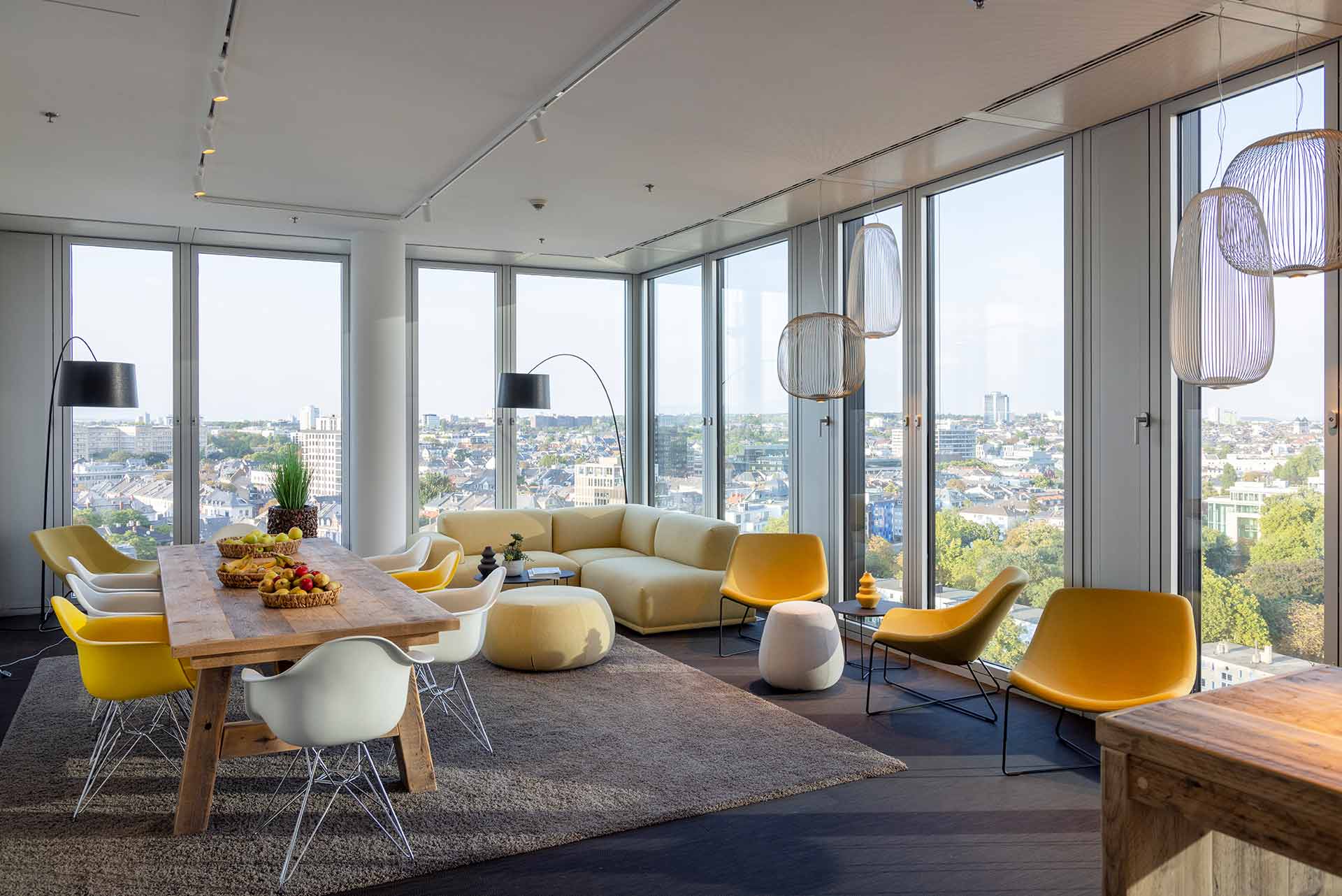 Heller Meetingraum mit Panoramablick und bunten Sitzmöbeln.