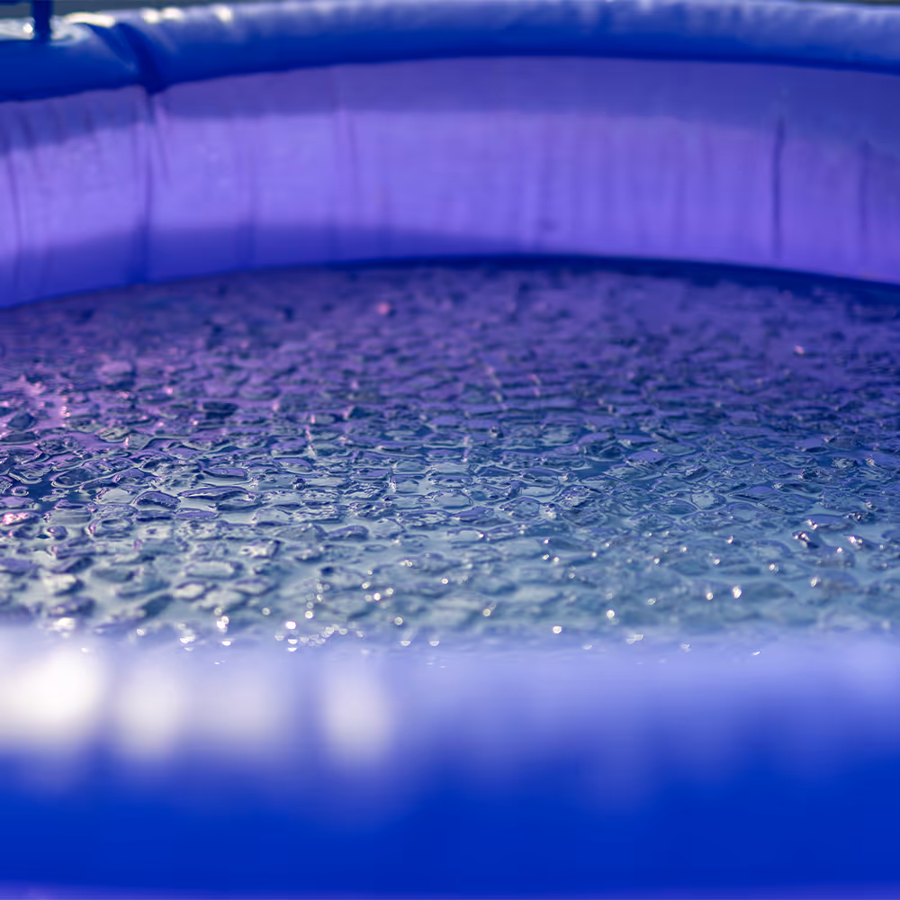 Nahaufnahme einer blauen, mit kleinen Eiskristallen bedeckten Wasseroberfläche in einem Pool.