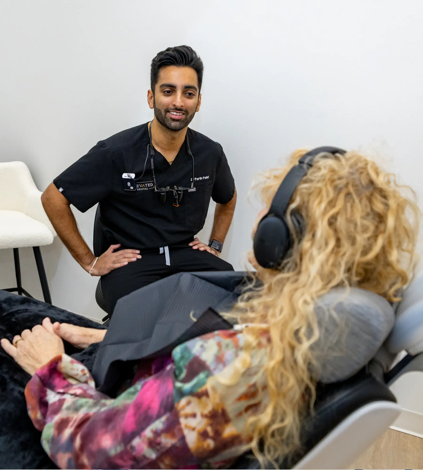 A man sitting in a dental chair, smiling at the camera.