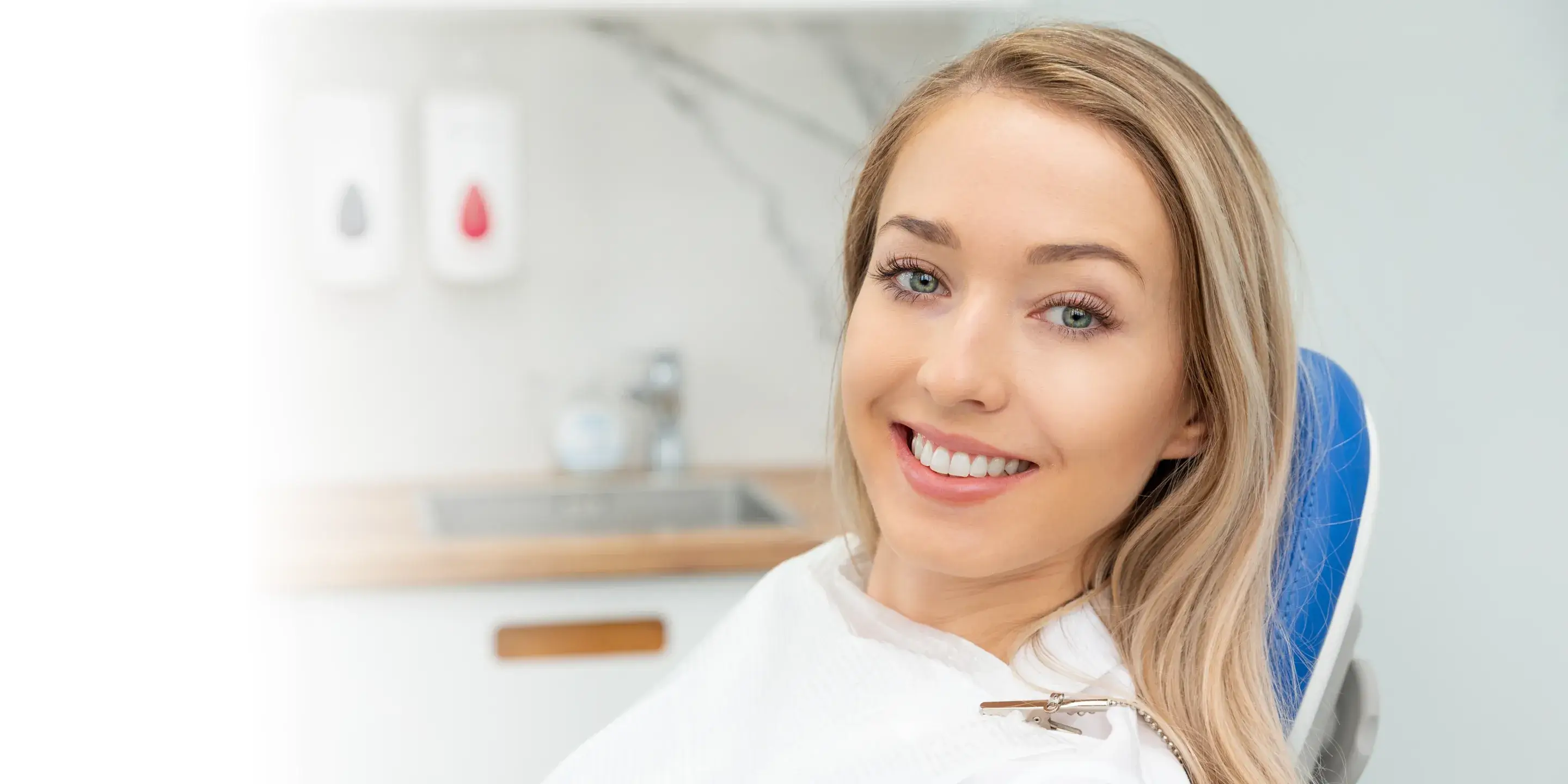A woman sitting in a chair smiling for the camera.