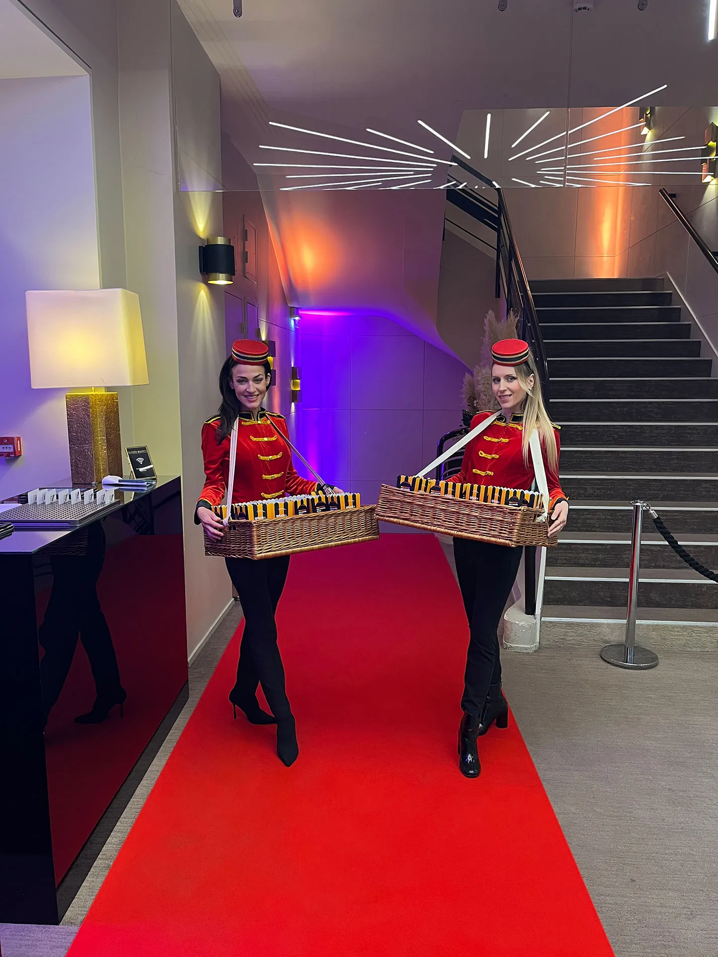 2 hôtesses offrant du pop corn en tenue d'ouvreuse sur un tapis rouge.