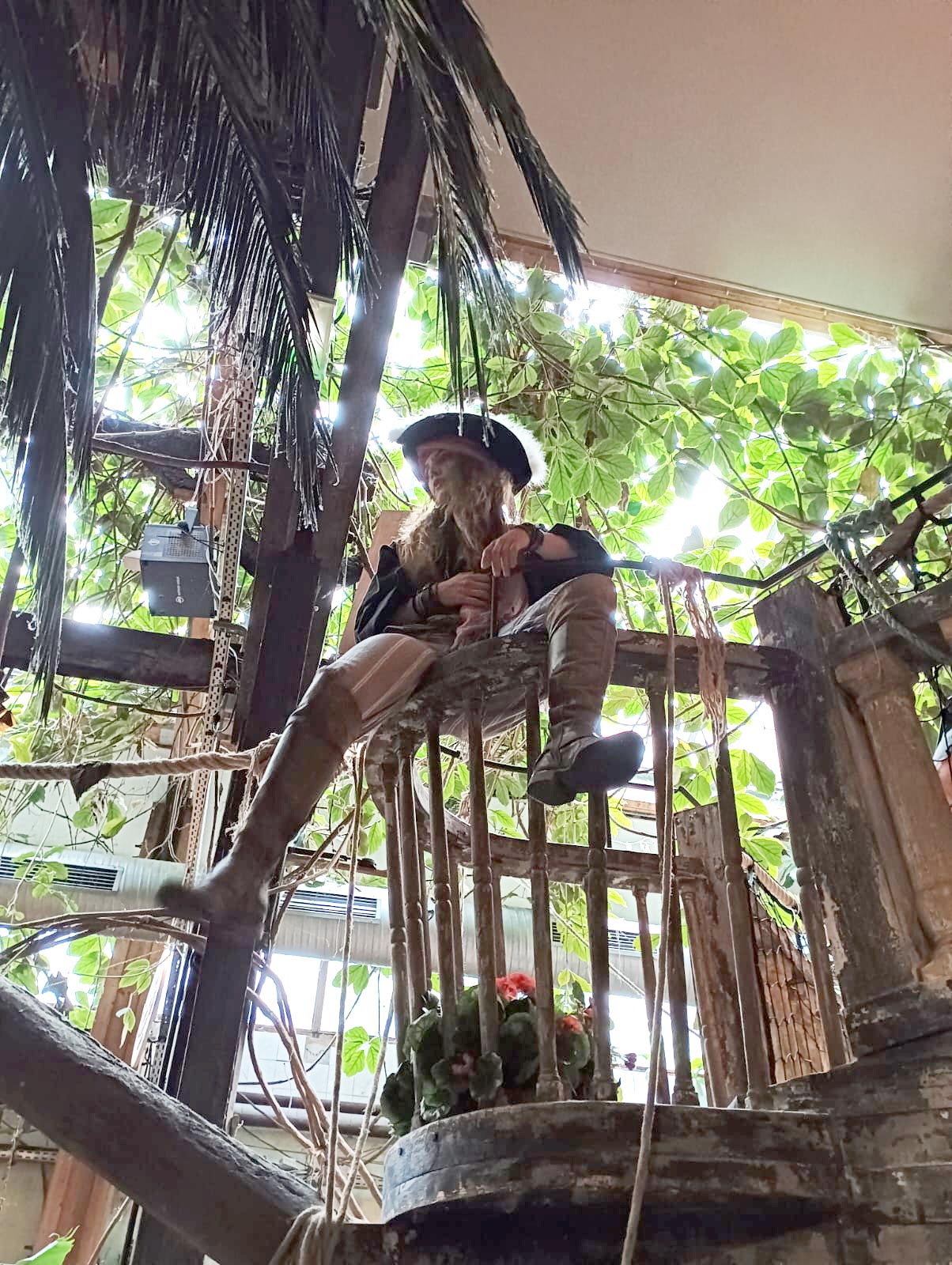 Une pirate perchée dans un décor caraïbéen.