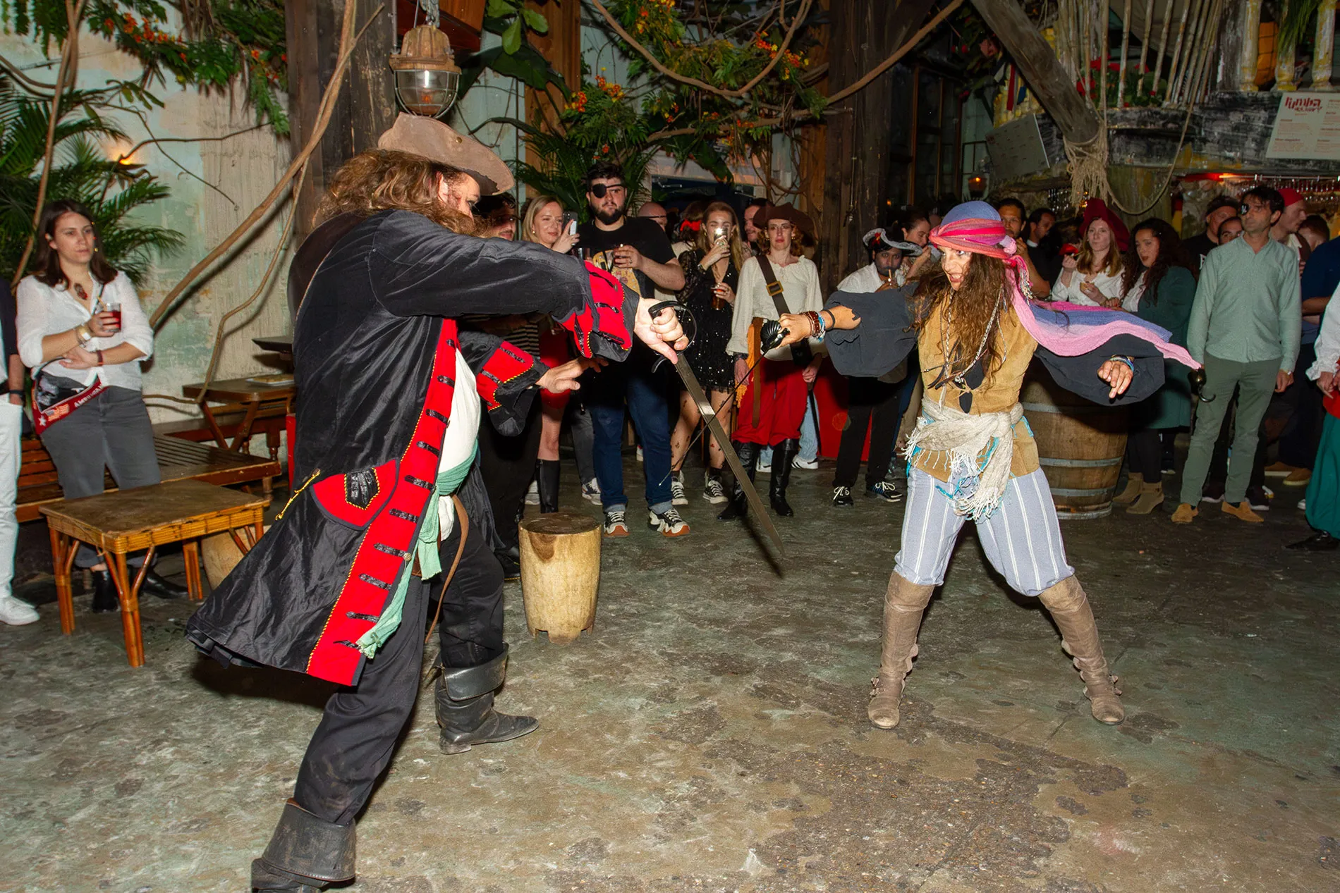 Des pirates se battent à l'épée devant des participants