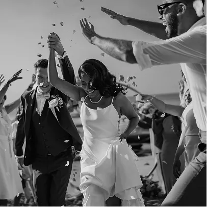 Couple de mariés français qui célèbre leur mariage à Bali, main dans la main tandis que leurs proches, amis et famille, leur lancent des pétales de fleurs balinaises.