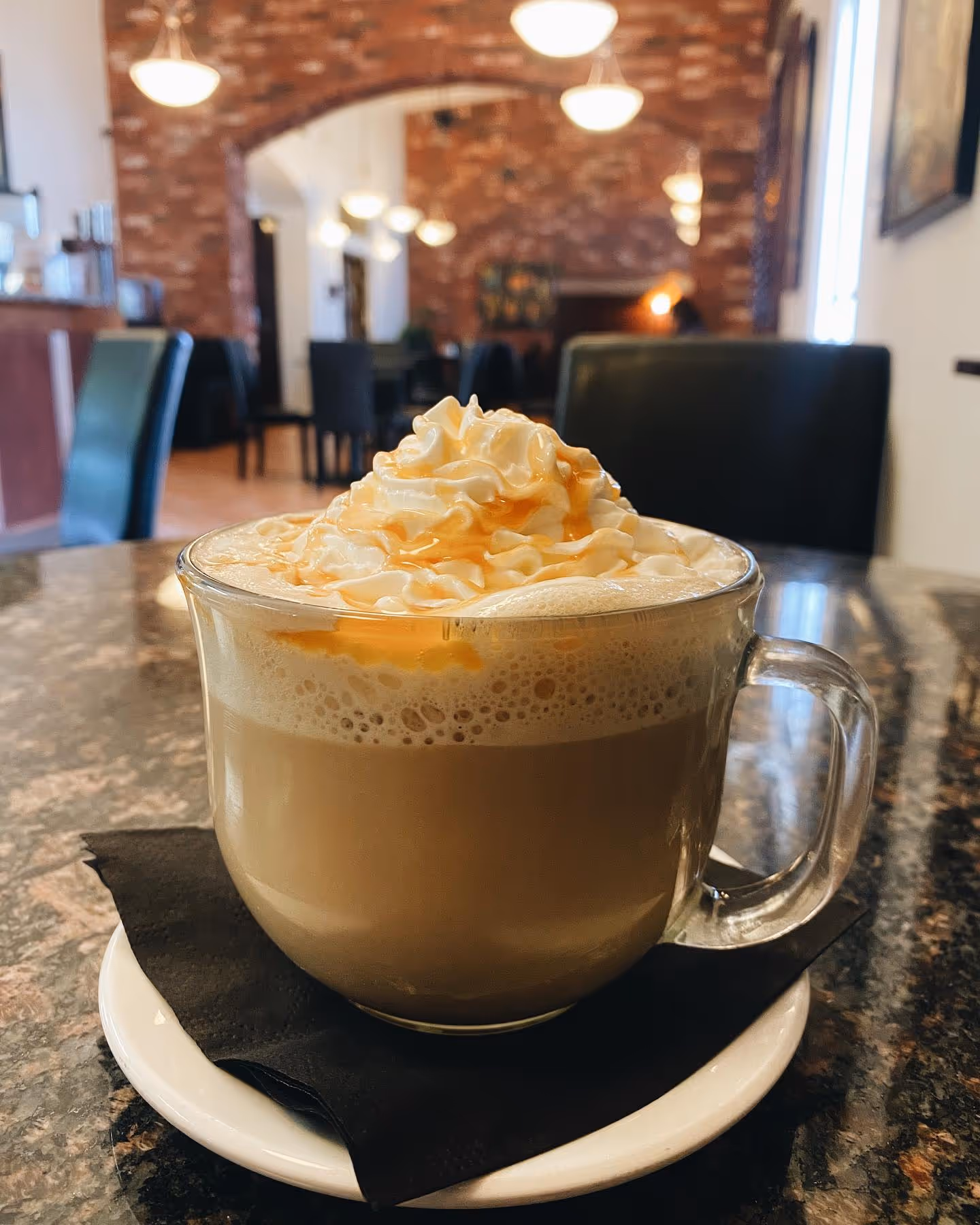 A cup of coffee with whipped cream on a table.