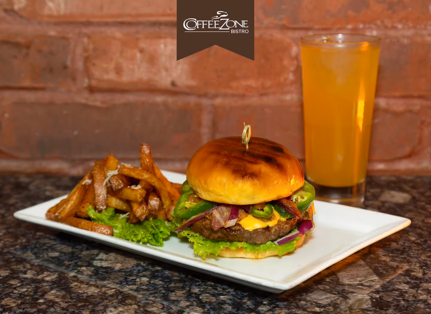 A burger with bacon and lettuce on a white plate.