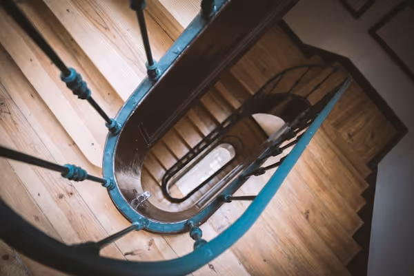 brown wooden spiral staircase with blue baluster