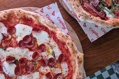Freshly baked Frenchie’s pepperoni pizza with mozzarella, served alongside a prosciutto and rocket pizza.