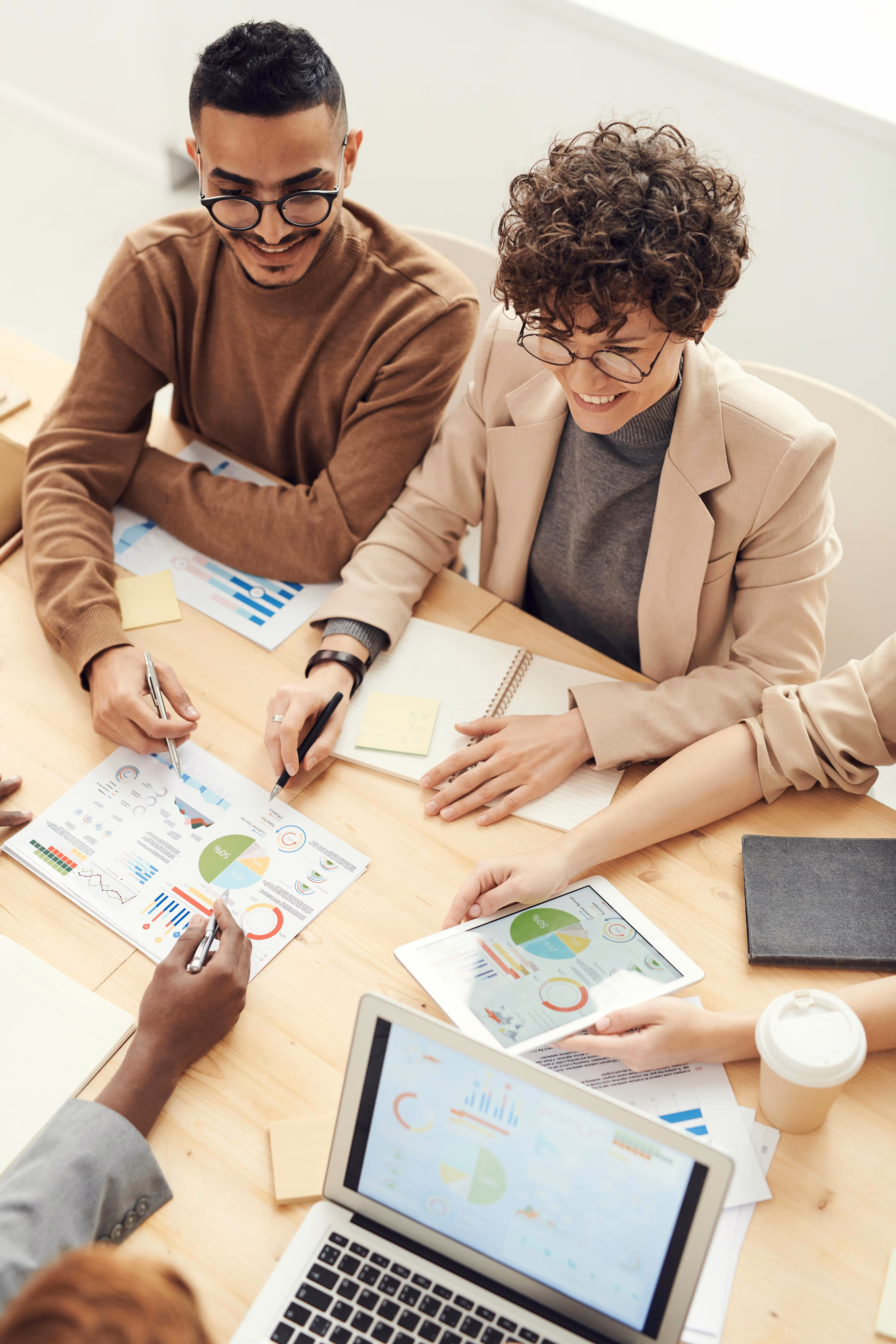 a group of people sitting around a table looking at papers