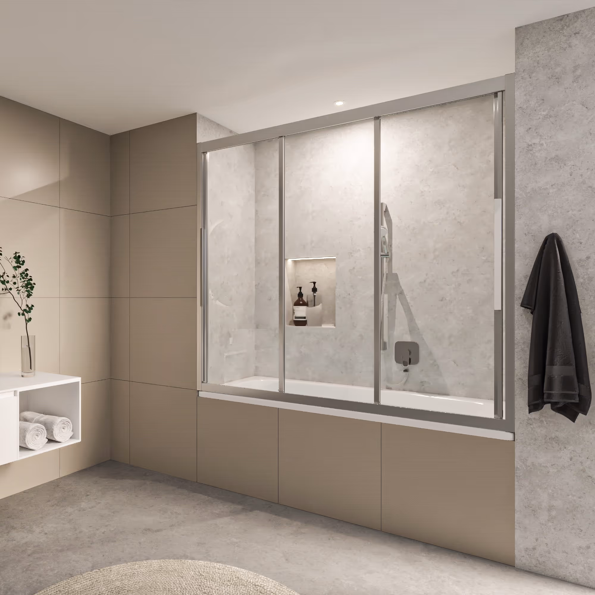 Une salle de bain aux tons neutres avec une baignoire encastrée équipée d'un pare-baignoire coulissant à trois panneaux de verre. Le sol et les murs sont recouverts de carreaux de couleur taupe, et une serviette grise foncée est suspendue à un crochet sur un mur en béton.