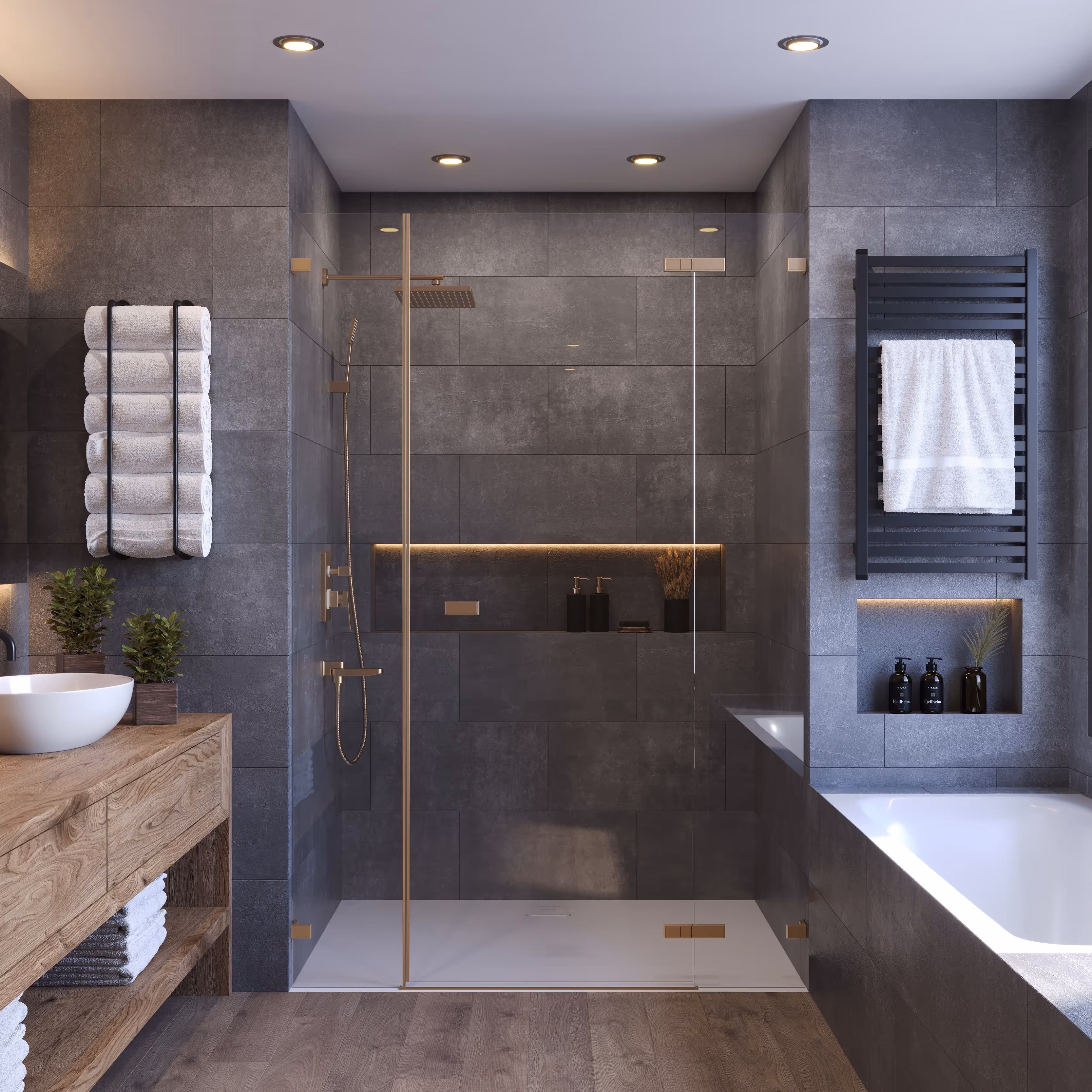 Une salle de bain sombre et élégante avec des carreaux de couleur ardoise sur les murs et le sol. La douche à l'italienne a une paroi en verre et une pomme de douche de couleur laiton. Une baignoire est encastrée à droite et une vanité en bois clair se trouve sur la gauche, sous un porte-serviettes.