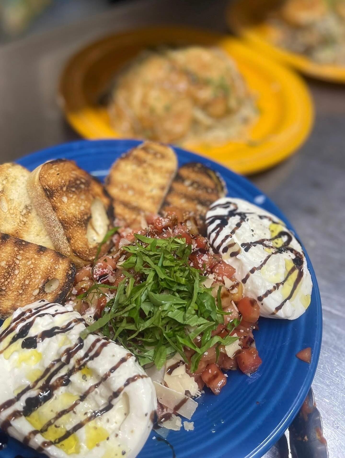 A serving of bread, juicy tomatoes, and cheese on a plate.