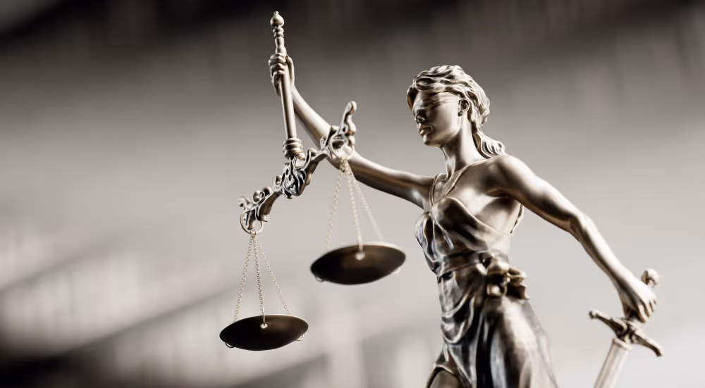 Bronzefigur der Justitia mit Augenbinde, Waage in der linken und Schwert in der rechten Hand.