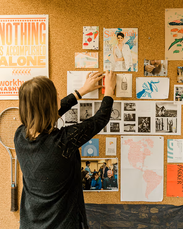 A woman hanging cards on the wall
