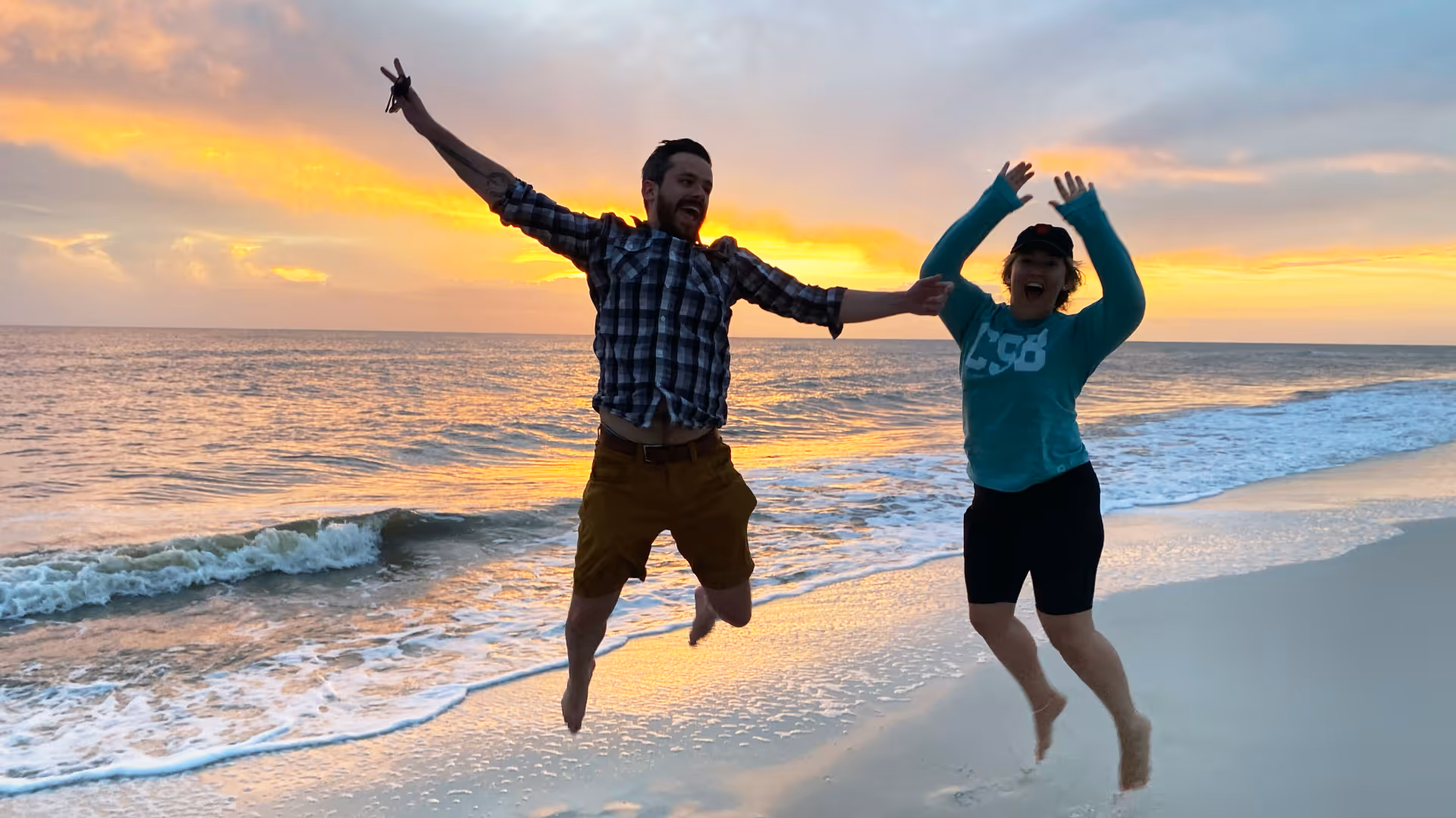 2 men jumping at the beach 