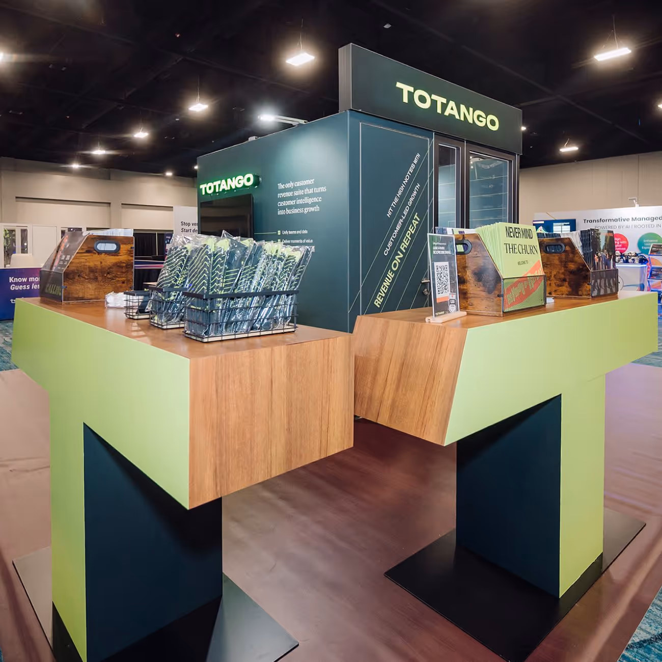 Modern trade show booth for Totango with green and wood design, promotional items, and informational displays.