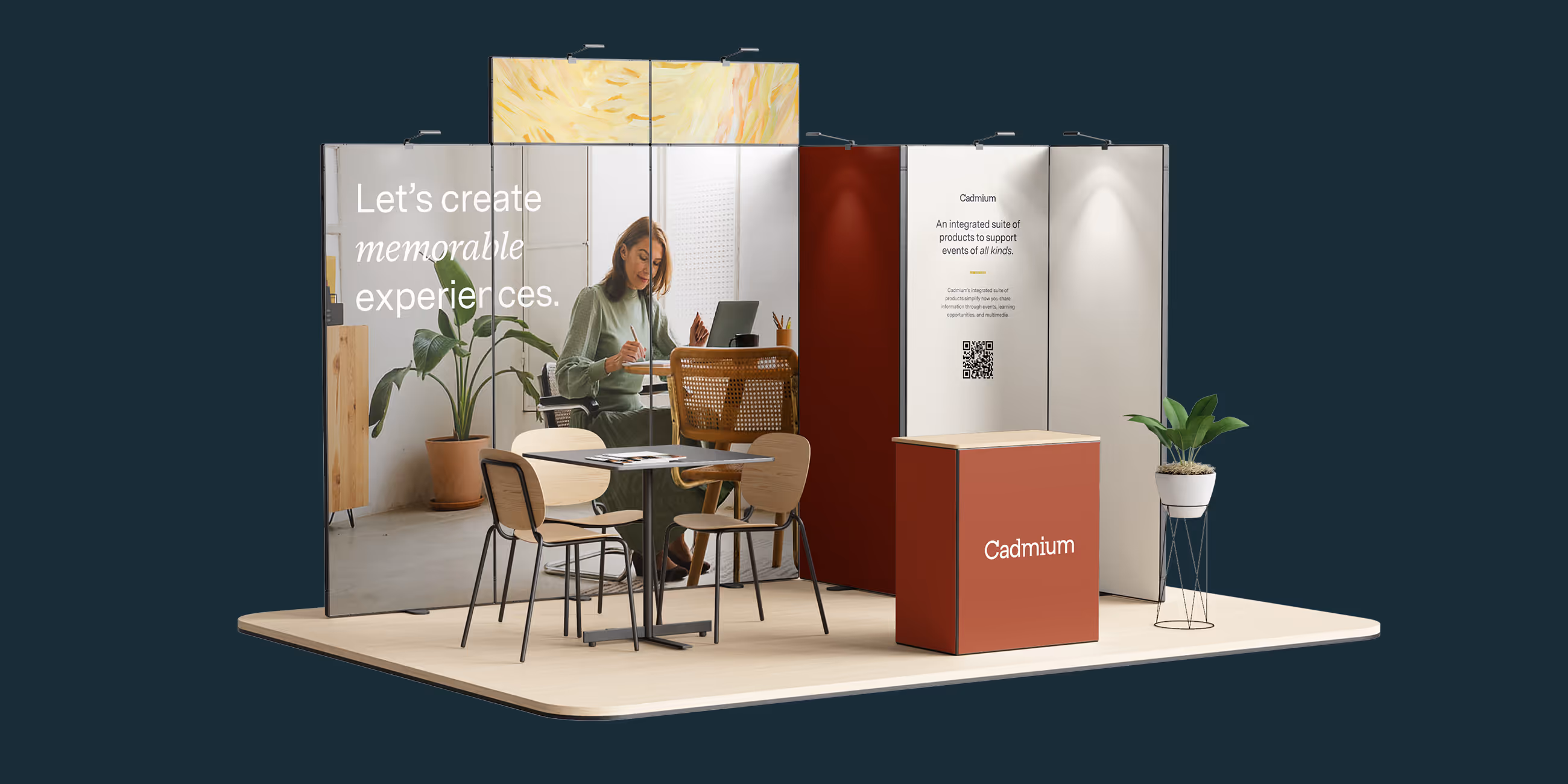 Exhibition booth setup with a table, chairs, plants, and large backdrop panels featuring a woman working and text about Cadmium event support products.