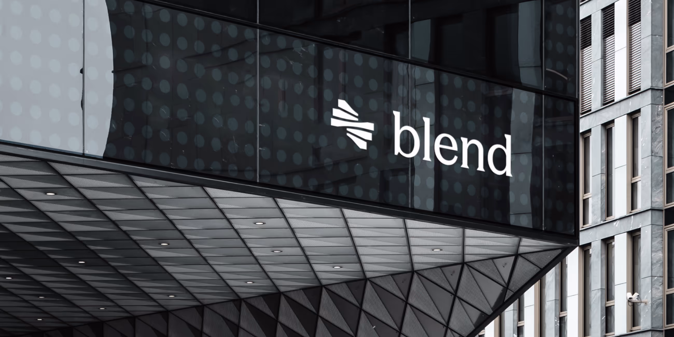 Modern building facade with a glass panel displaying the white Blend logo and name.