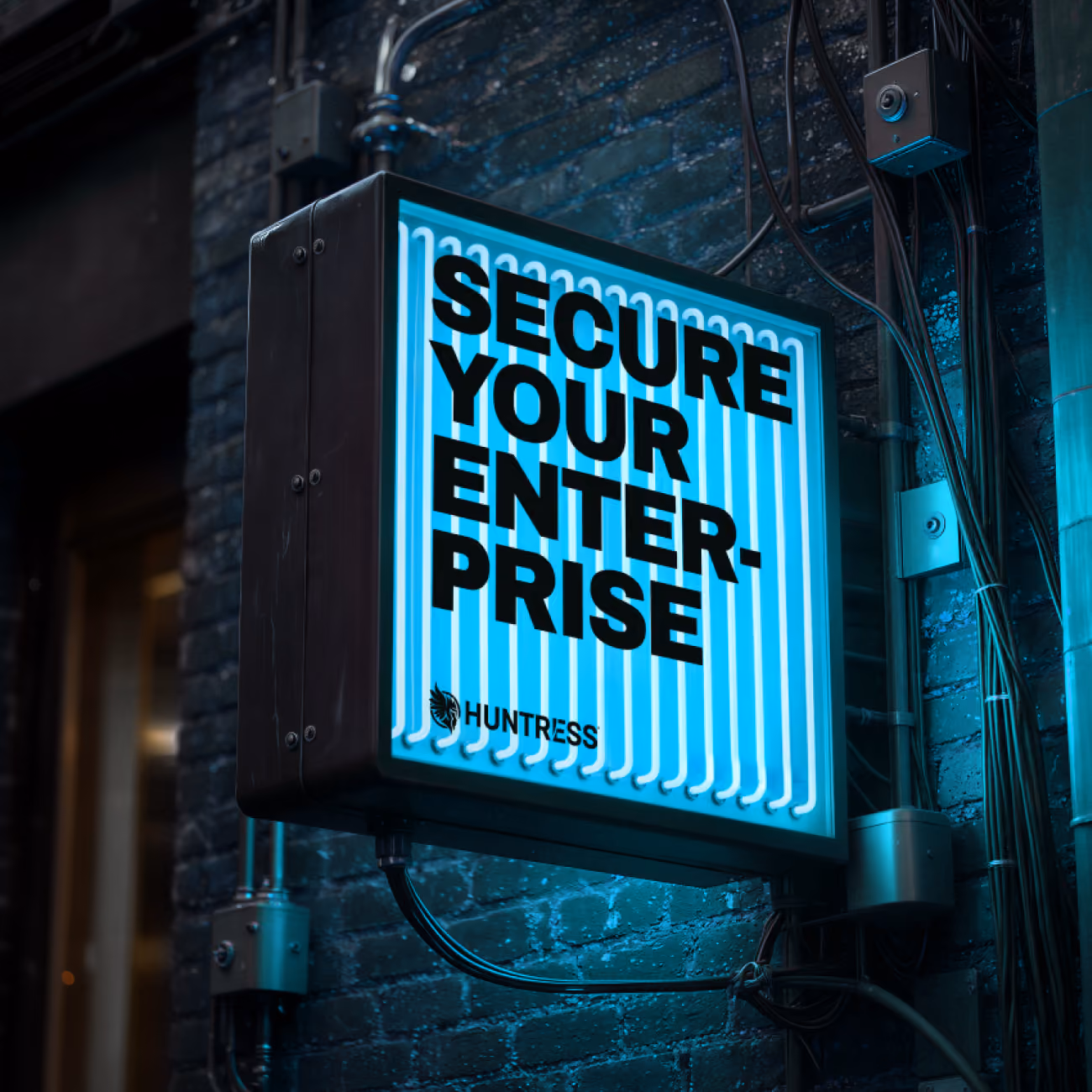 Glowing neon sign on brick wall reads 'SECURE YOUR ENTERPRISE' with Huntress logo below.