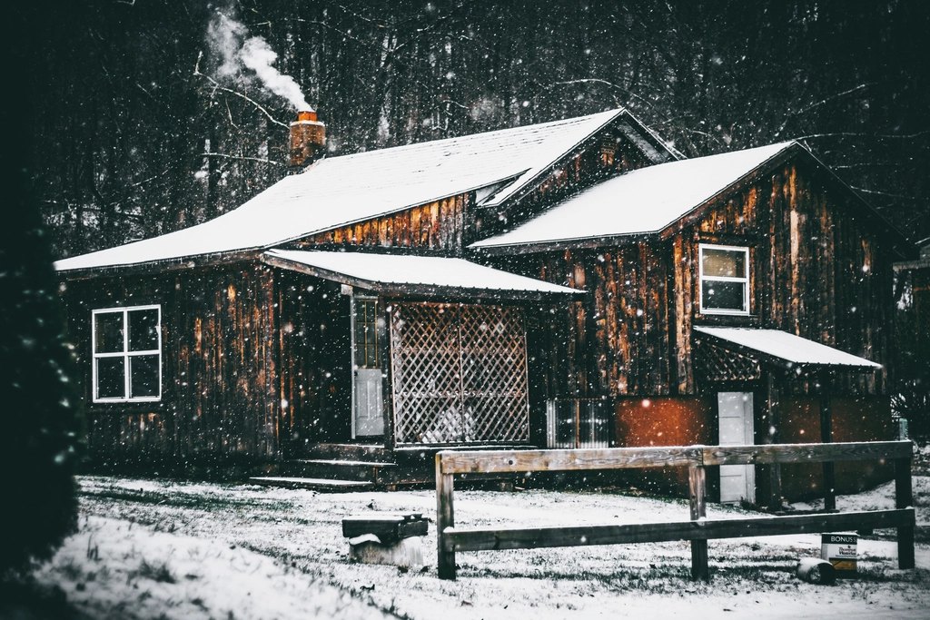 Toit couvert de neige sur une maison de bois en hiver au Québec