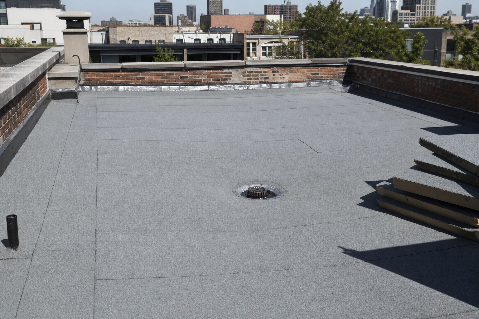 Toit plat de plex montréalais avec drain central et panneaux d'isolant biseautés servant à créer l'écoulement.