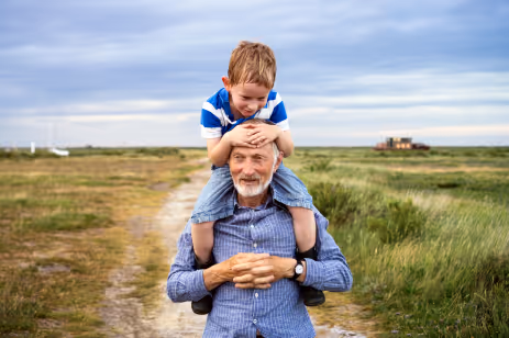 A Picture of a grandfather and grandson sharing a cheerful moment outdoors