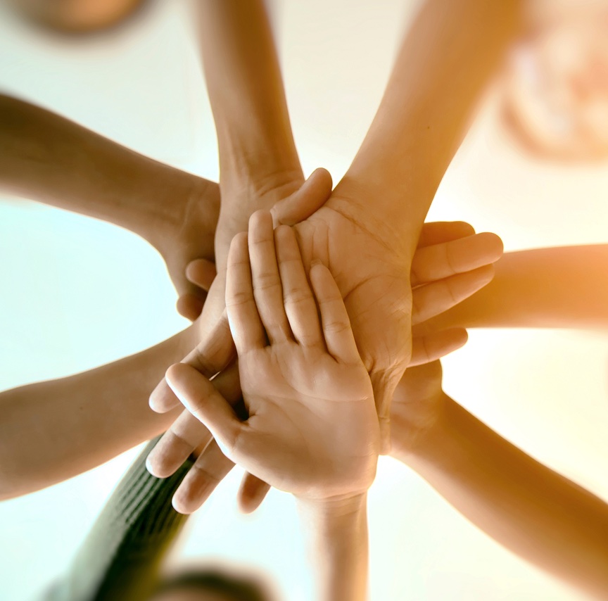 A photograph of hands coming together representing collaboration
