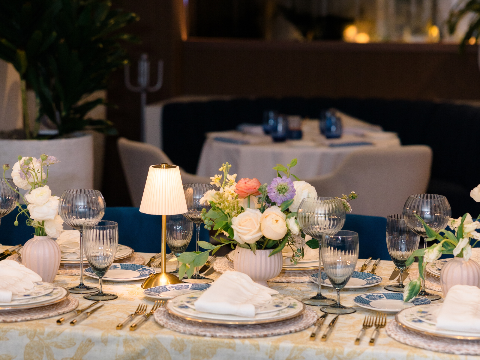 Table set with plates, glasses and flowers in a restaurant