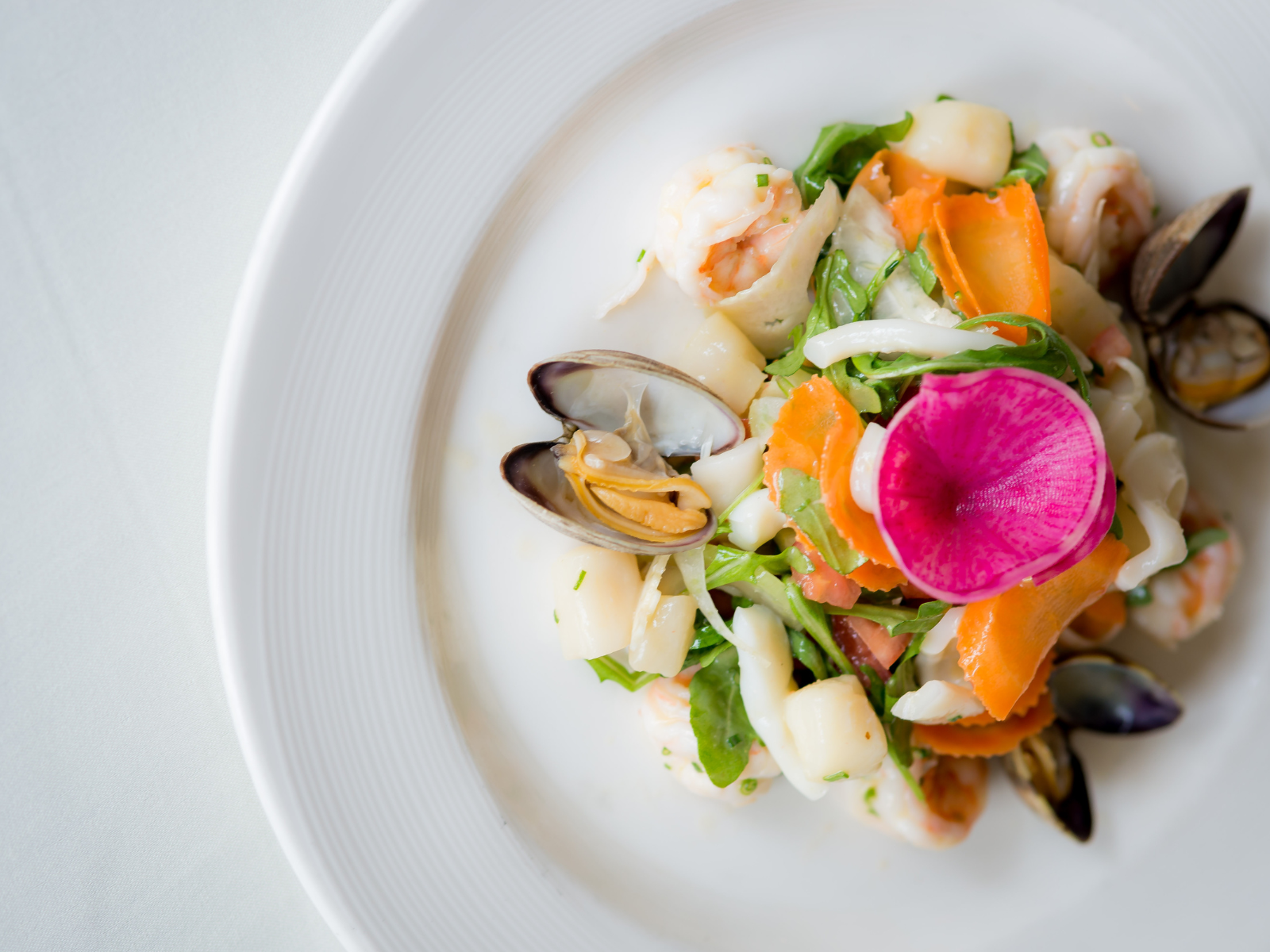 Seafood and vegetable dish on a white plate