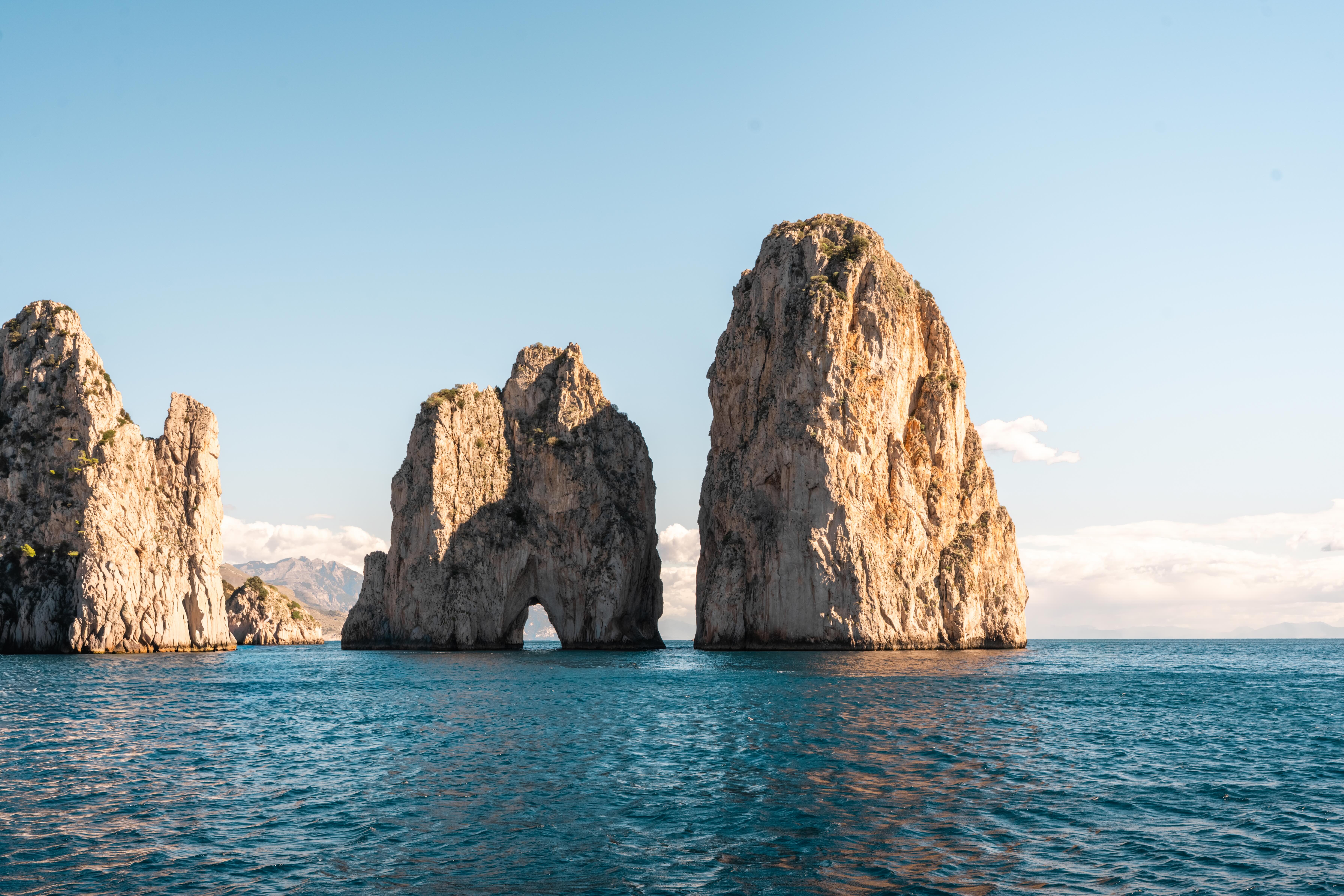 Faraglioni rocks in Capri, Italy, with blue sea and natural stone arch