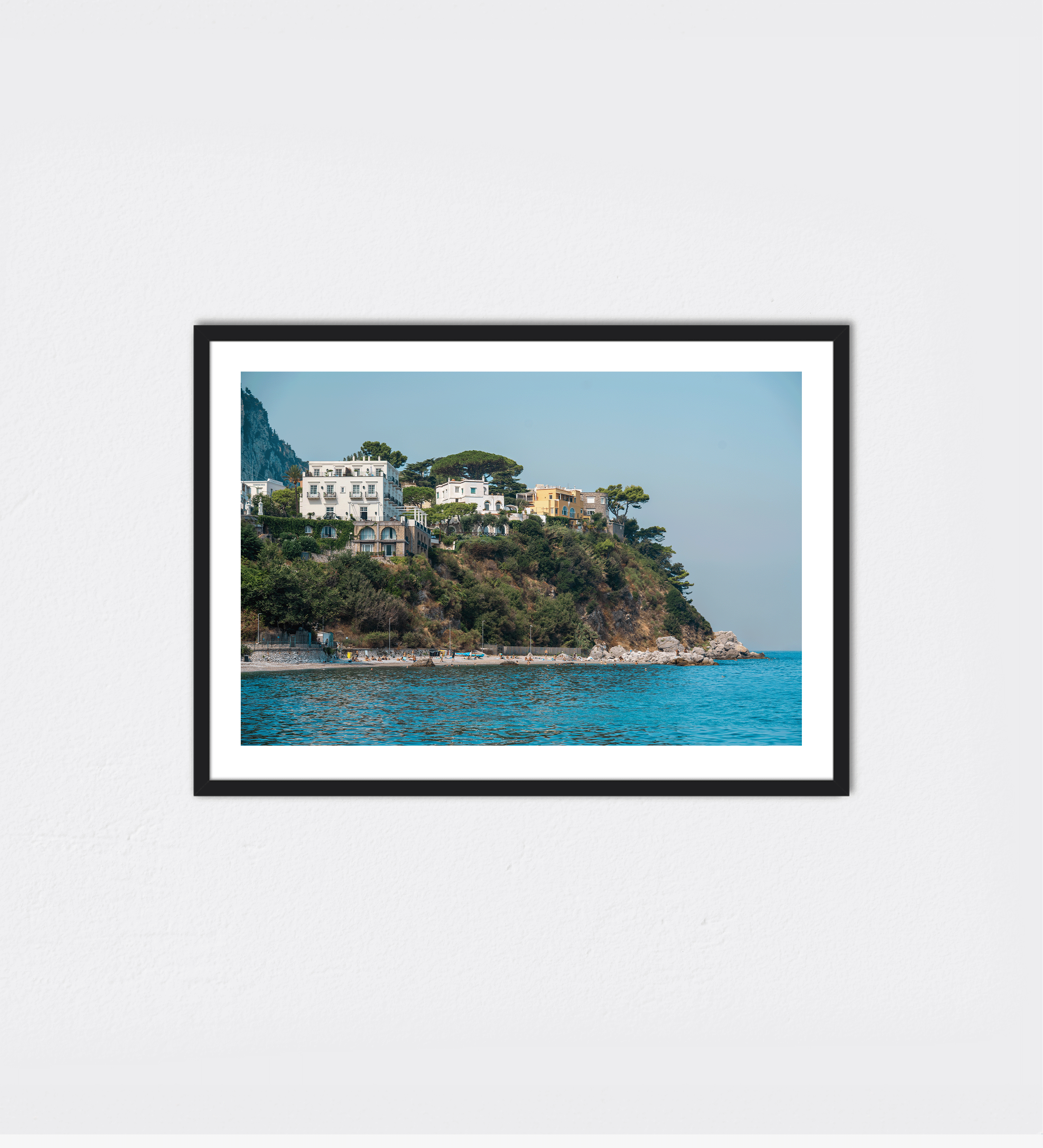 Coastal view of pastel villas perched on a dramatic clifftop above the Tyrrhenian Sea along the Amalfi Coast, Italy.