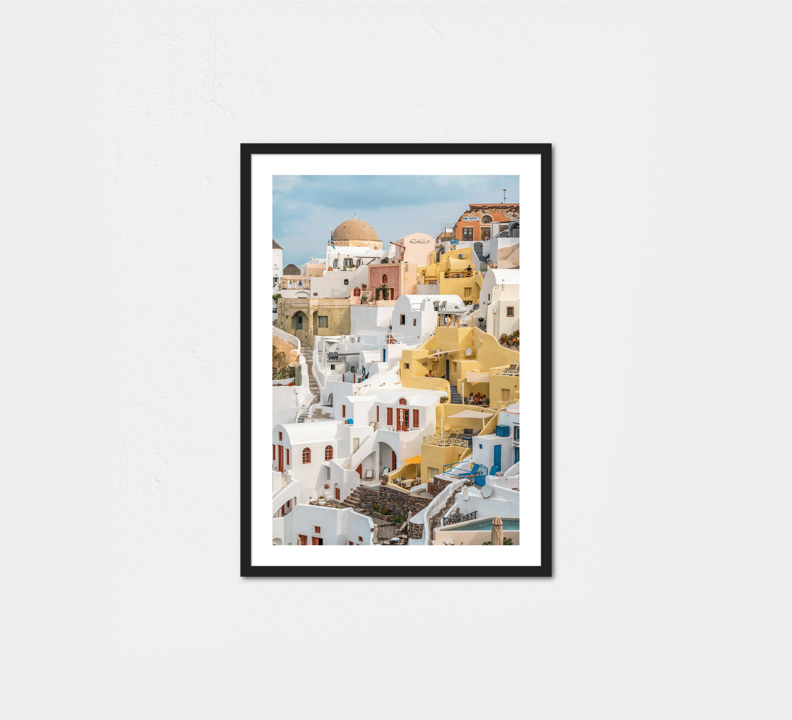 A sun-drenched moment in Oia, where golden-hued buildings cascade alongside the iconic whitewashed structures.