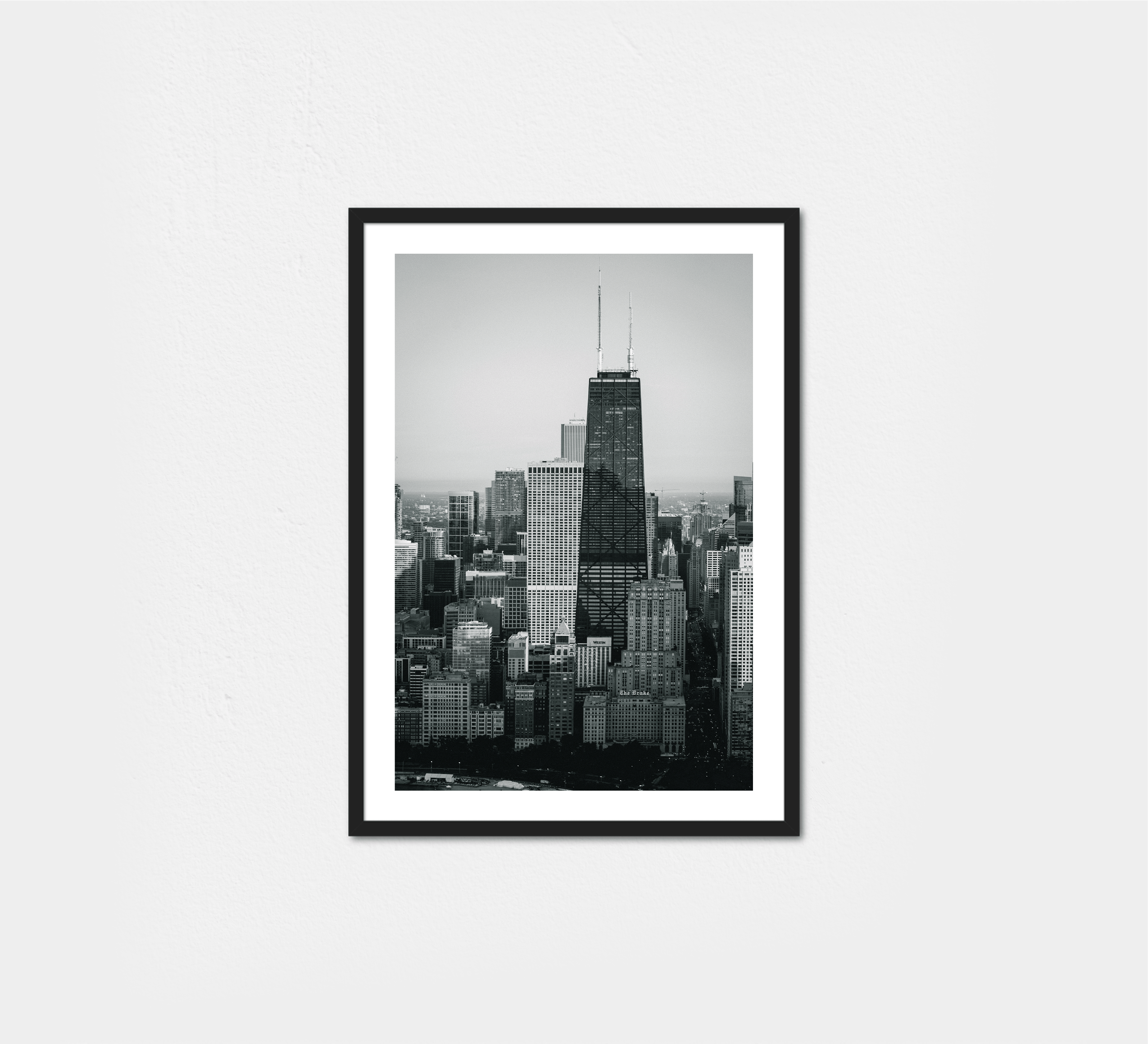 The John Hancock towers above Chicago's dense skyline, rising over neighboring buildings.