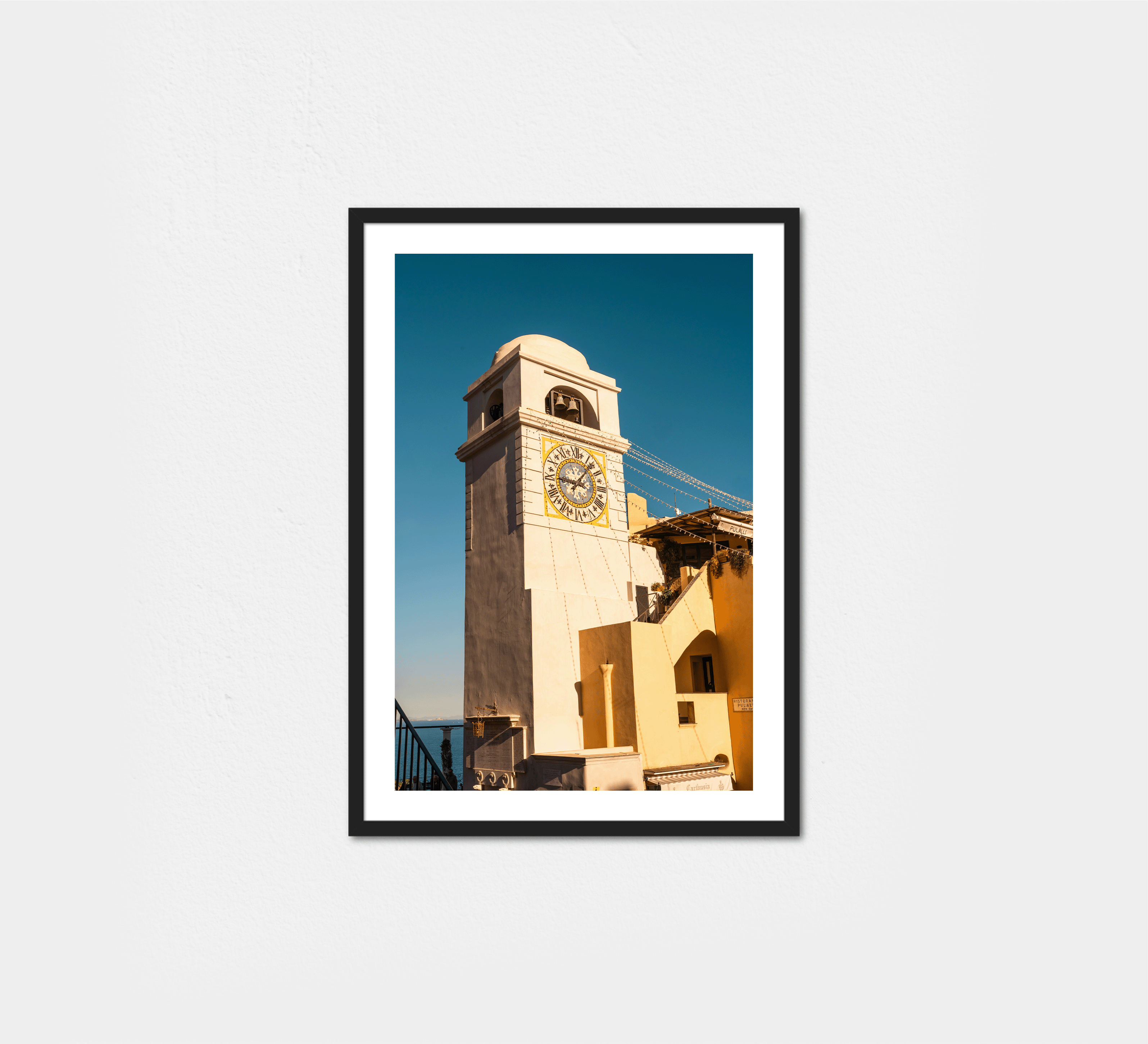 The iconic clock tower in Capri's Piazza Umberto I, its golden face gleaming against deep blue sky.
