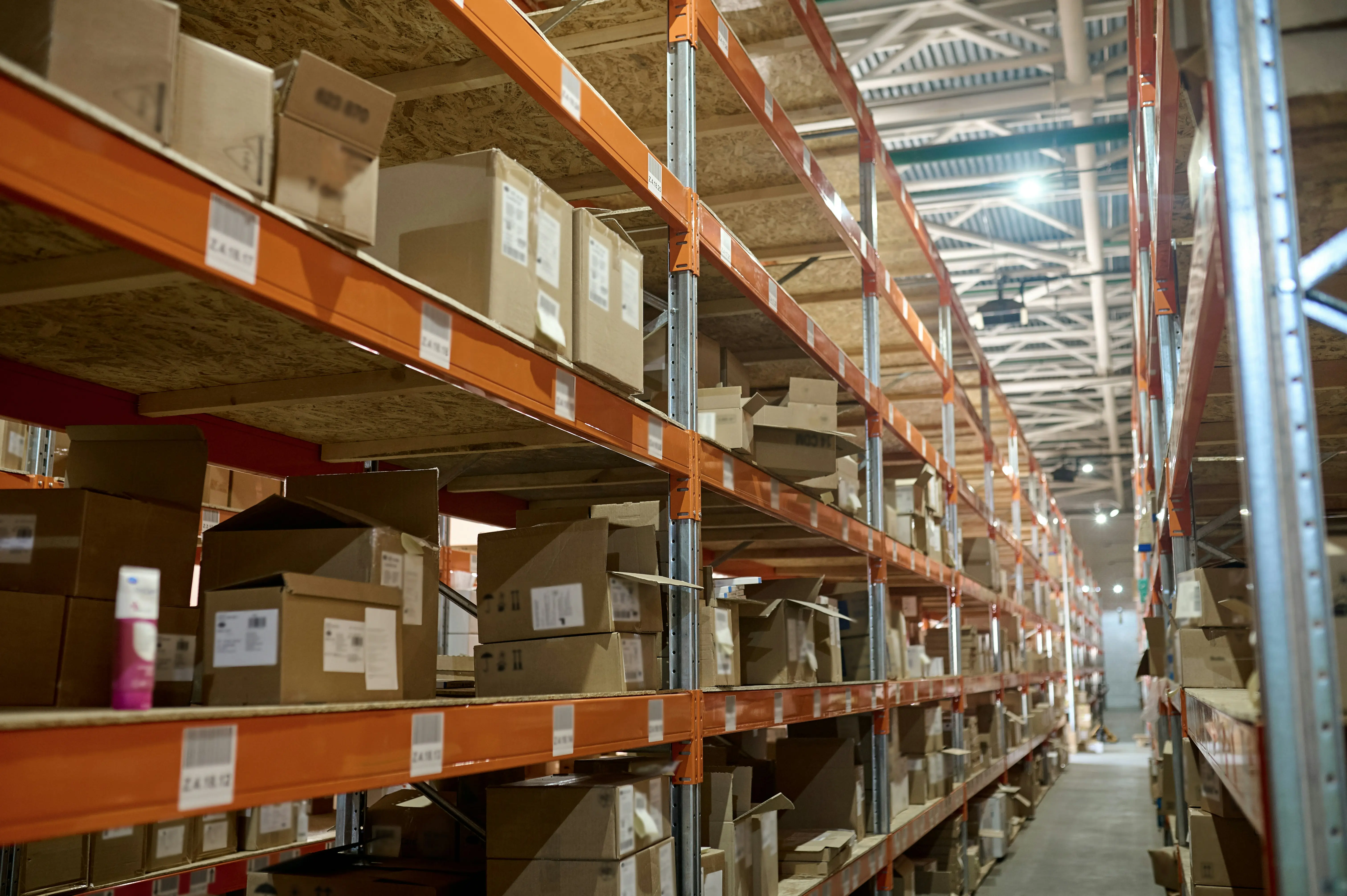 A warehouse with tall shelves full of cardboard boxes.