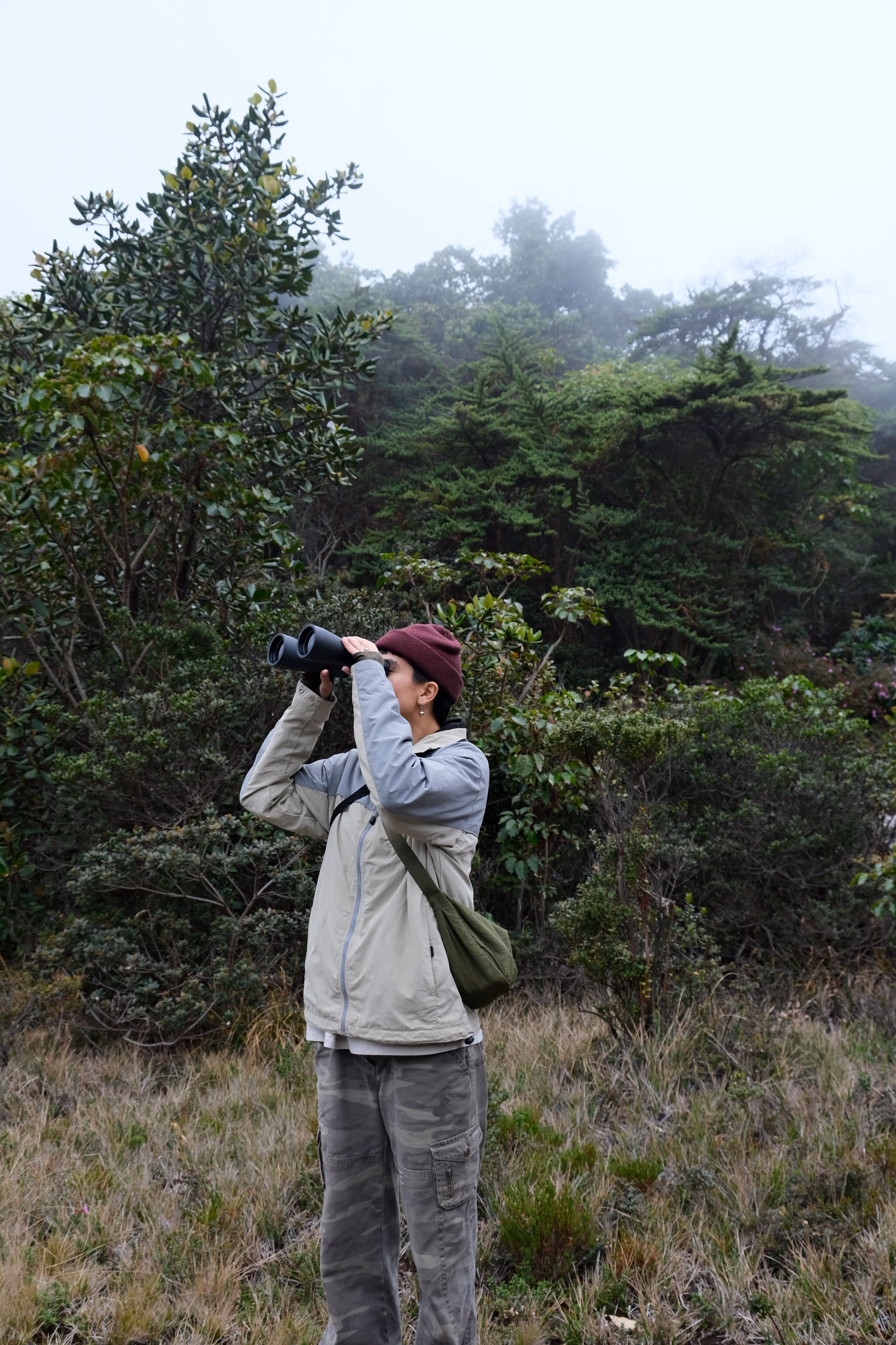 Giuliana, AI developer at CRSS, using binoculars to look into the distance outdoors.