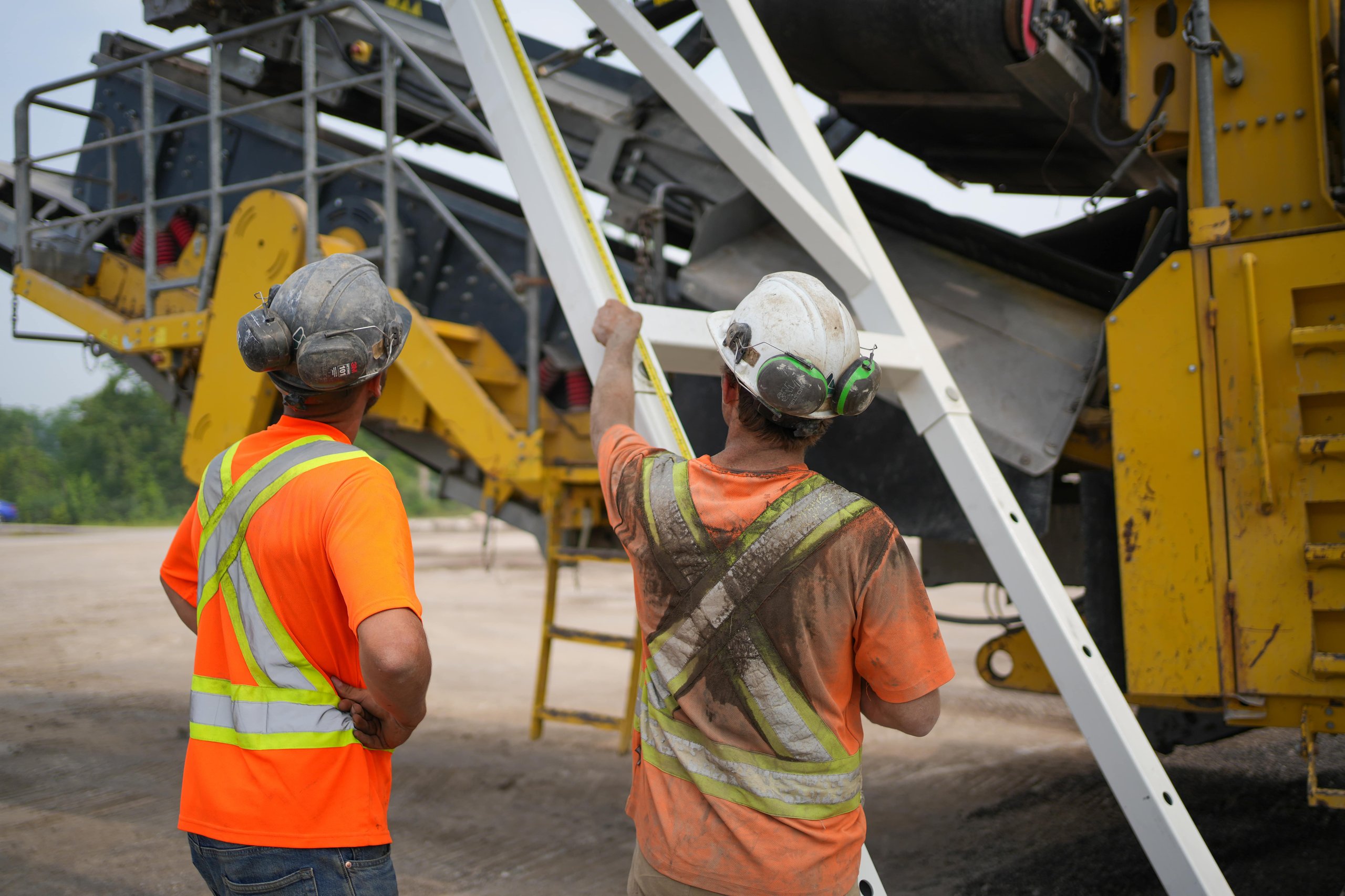 Photo of two construction workers on site measuring materials, symbolizing ER Media’s hands-on approach and precision in building reliable digital solutions.