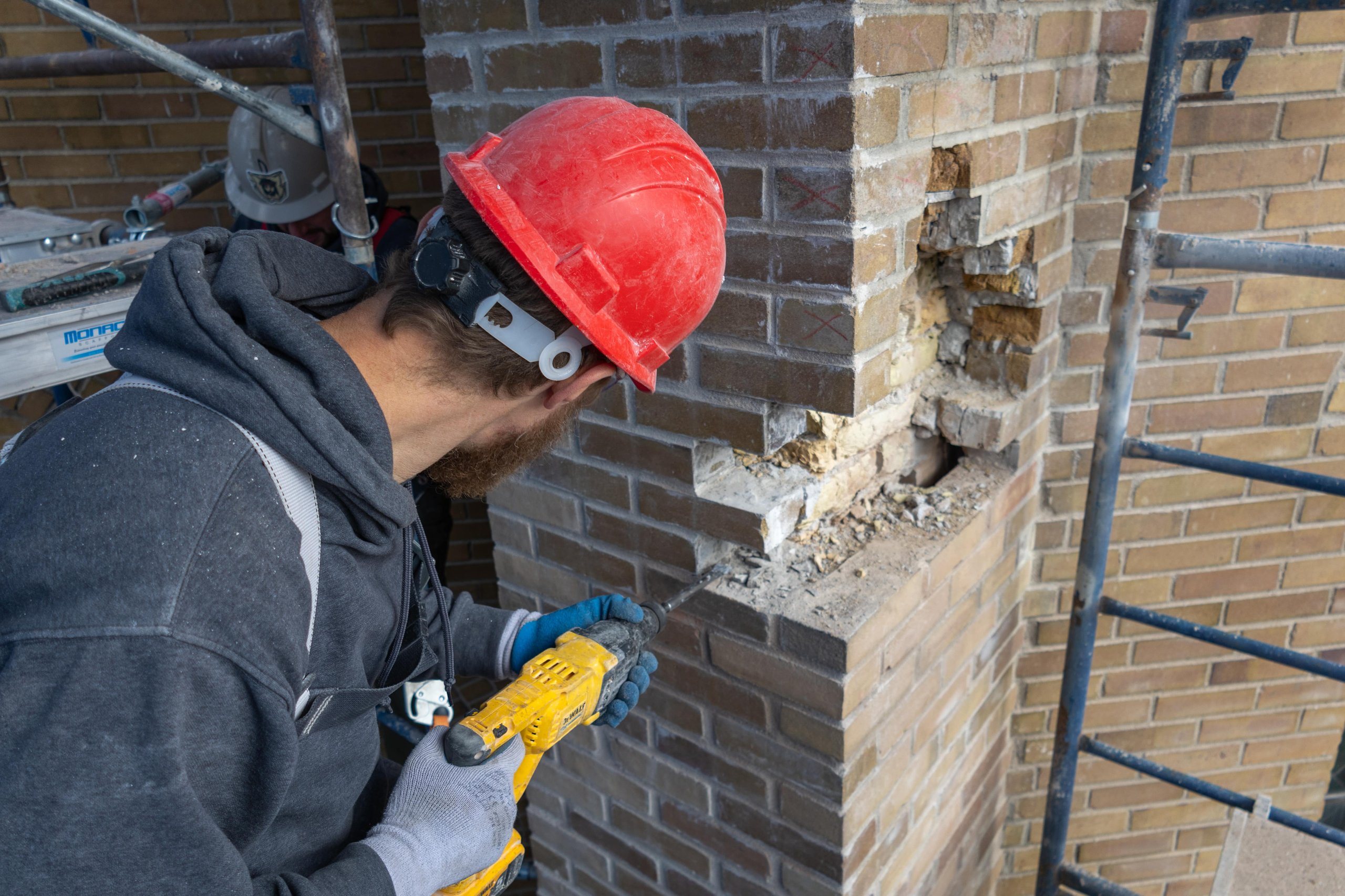 Photo of a construction worker removing old bricks, symbolizing renewal, craftsmanship, and ER Media’s commitment to helping Ontario contractors build stronger foundations.